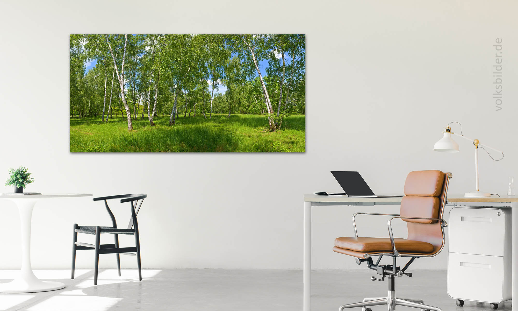 Das Foto zeigt ein Büro mmit einem Schreibtisch und einem Bürostuhl. Im Hintergrund an der Wand hängt ein Wandbild, das einen Birkenwald zeigt.